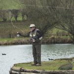 An angler is standing and casting fish during a Sunday fly fishing day