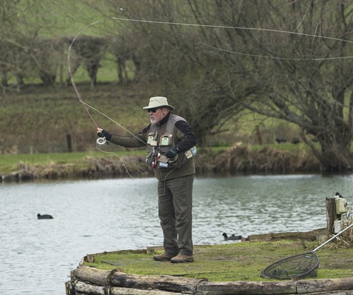 An angler is standing and casting fish during a Sunday fly fishing day