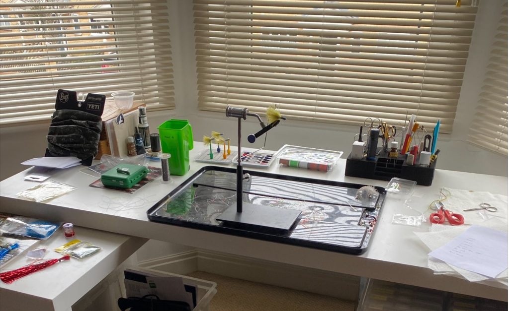 Organised fly tying desk with tools and materials neatly arranged for efficient fly tying.